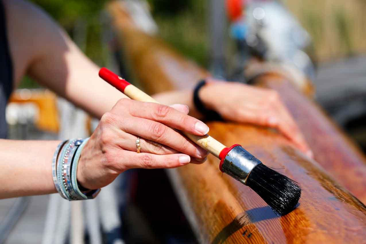 wooden-mast-of-a-classic-sailing-yacht Varnishing the wooden mast of a classic sailing yacht